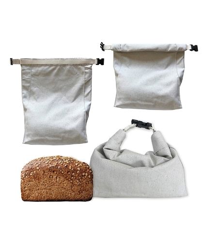 3 white bags made from hemp fabric next to a loaf of bread