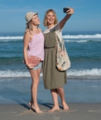 Two ladies taking a selfie on the beach, one of them carrying the hemp twine moon beach bag